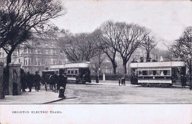 Trams passing the bottom of Victoria Gardens. The Victoria statue is behind the tram on the right.