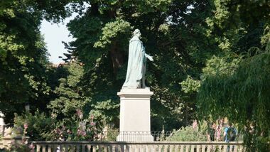 Side view of the statue, looking North from Pavilion Gardens, with Victoria Gardens in the background (on the far side of a road)
