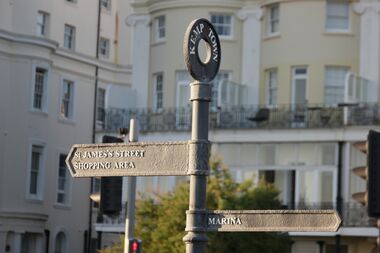 Kemp Town signage on the seafront, East: "St James Street Shopping Area", West: "Marina"