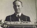 Surgeon Commander EJ Littledale, with his model of hospital ship RFA Maine.jpg