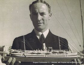 Surgeon Commander Chris Littledale holding his model of the RFA Maine
