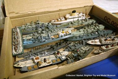 A collection of ~1:1200 waterline ship models in metal and wood, waiting to be sorted and priced for the museum's Collectors' Market