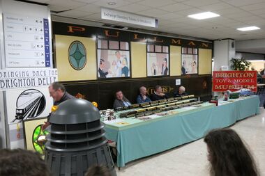 2016: "Bringing Back the Brighton Belle". The 5BEL Trust's publicity stand, being inspected by a Dalek, at Brighton Modelworld 2016. For this year, the car's windows were populated by reproduced sections of Terry Smith's Trafalgar Street Brighton Belle mural.