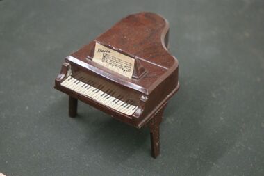 Kleeware dollhouse piano, with the Kleeware script logo printed on its sheet music